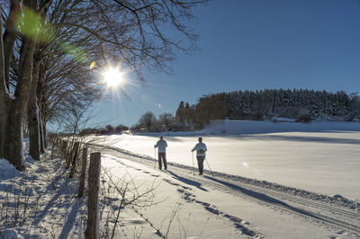 Couple walking on snow covered field