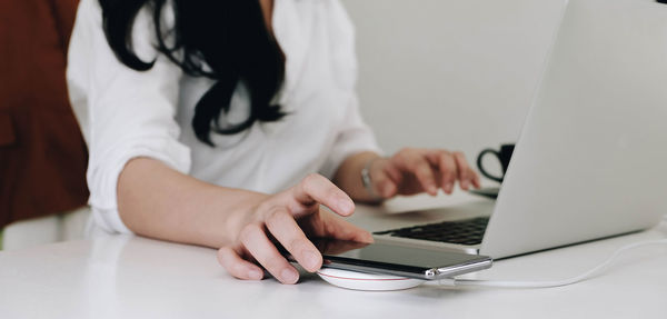 Midsection of woman using mobile phone