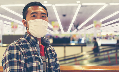 Portrait of man wearing mask in shopping mall