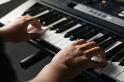 Man playing synthesizer at home, taking virtual lessons