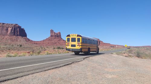 Car on road against clear blue sky