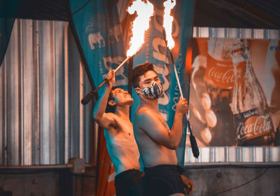 Young man holding hands hanging at music concert