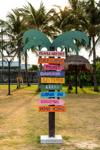 Information sign by palm trees in park