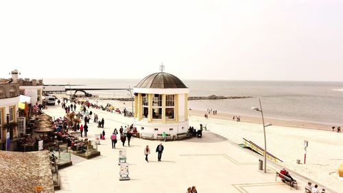 People on beach against clear sky