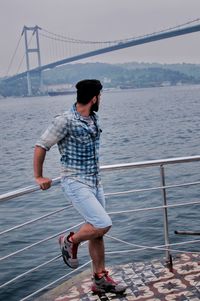 Full length of man on bridge over sea against sky