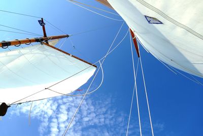 Low angle view of sailboat against blue sky