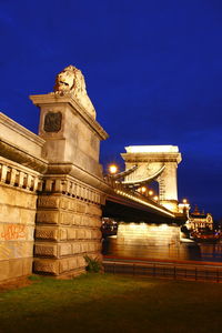 Low angle view of illuminated bridge against blue sky