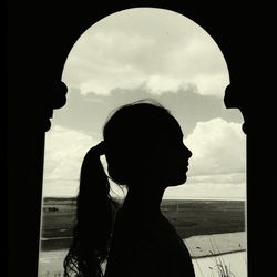 Silhouette of woman against cloudy sky