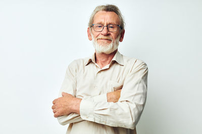 Portrait of senior man standing against white background