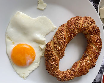 High angle view of breakfast in plate. traditional turkish sesame ring aka simit and fried egg 