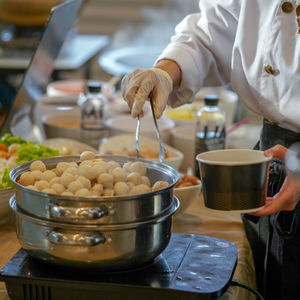 Midsection of person preparing food in kitchen