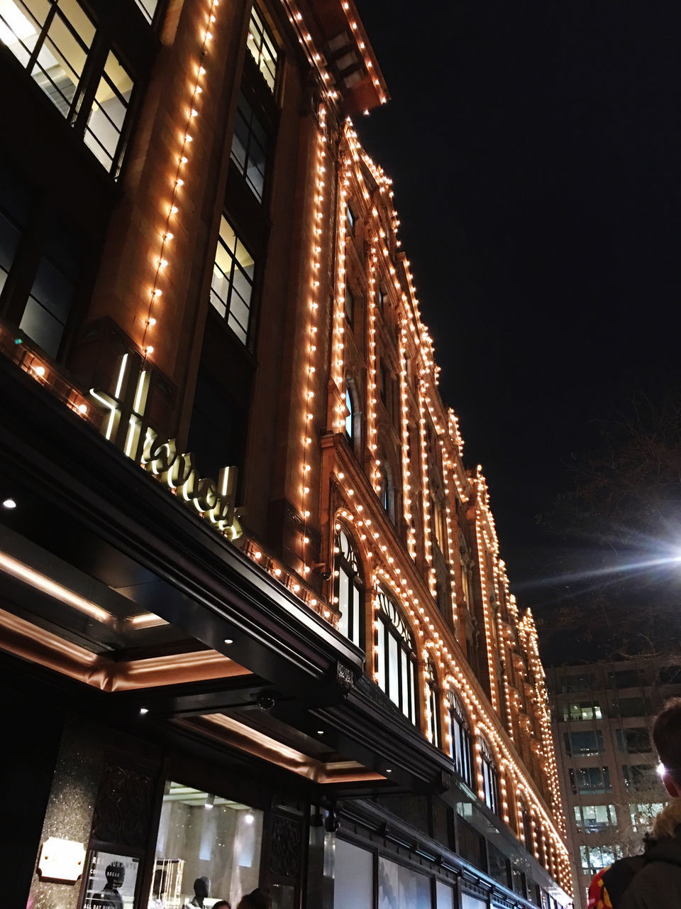 LOW ANGLE VIEW OF ILLUMINATED BUILDING AGAINST SKY AT NIGHT