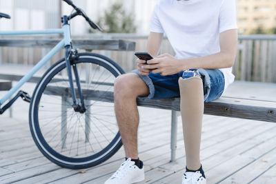 Disabled bicyclist browsing smartphone in city