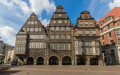 Low angle view of buildings against cloudy sky