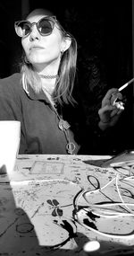 Portrait of woman wearing sunglasses on table