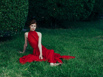 Portrait of young woman sitting on lawn