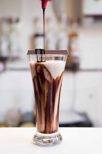 Close-up of chocolate syrup pouring in coffee