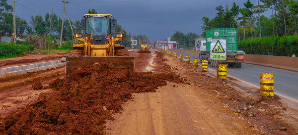 Construction site by road against sky