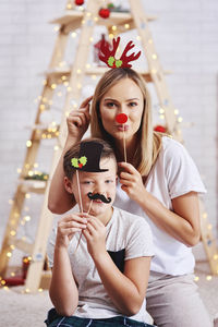Portrait of mother and son with props at home during christmas