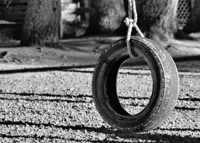 Close-up of tire hanging over footpath