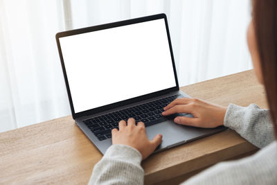 Midsection of woman using laptop on table