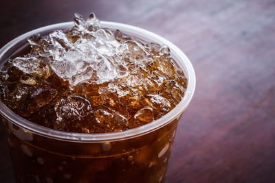 Soft drinks in plastic cups on the wooden floor.