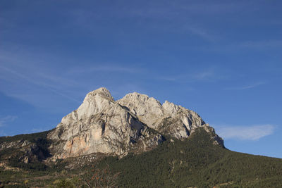 Low angle view of rocky mountain against sky