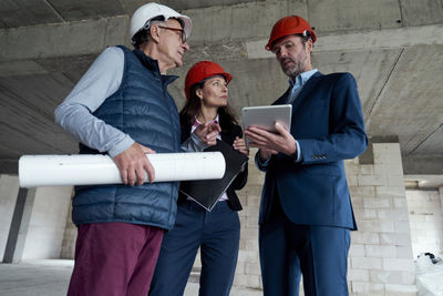 Low angle view of engineers brainstorming at construction site