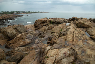 Rock formation on beach against sky