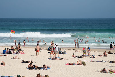 People on beach against clear sky