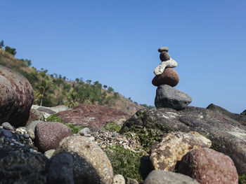 Stack of stones against clear blue sky