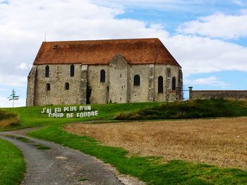 Built structure on field against cloudy sky