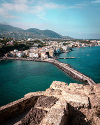 High angle view of townscape by sea against sky