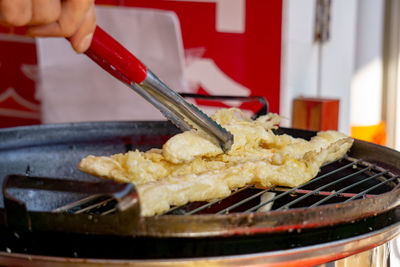 Close-up of person preparing food on barbecue grill