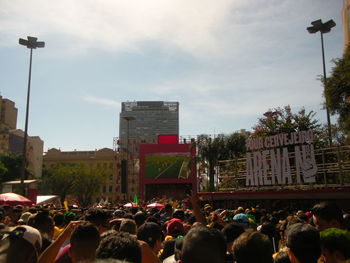 People on street in city against sky