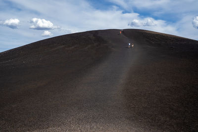 Person on desert land against sky