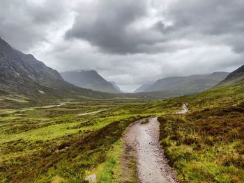 Road leading towards mountains against sky