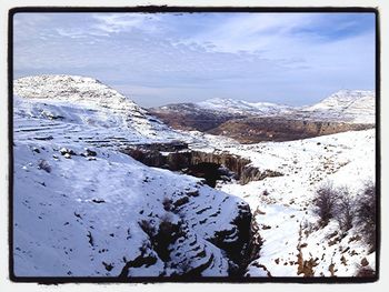 Scenic view of snow covered mountains against sky