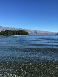 Scenic view of calm sea against clear blue sky