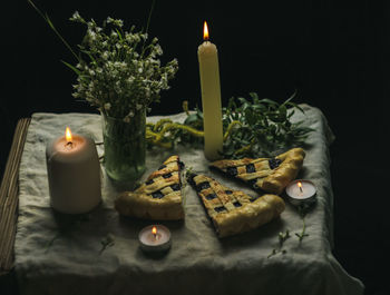 Close-up of illuminated candles on table