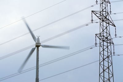 Low angle view of electricity pylon against clear sky