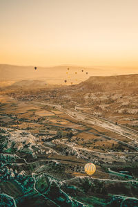 View of hot air balloons on field against sky during sunset