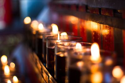 Close-up of illuminated tea light candles in church