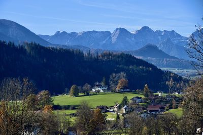 Scenic view of trees and buildings against mountains and sky