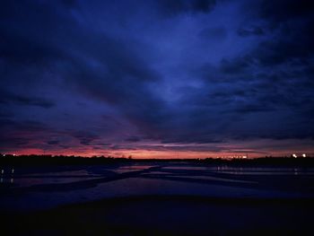 Scenic view of sea against dramatic sky at sunset