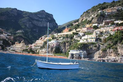 Boats in sea with town in background