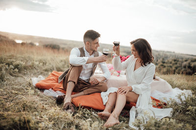 Rear view of couple sitting on land