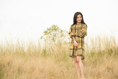 Portrait of young woman standing in field