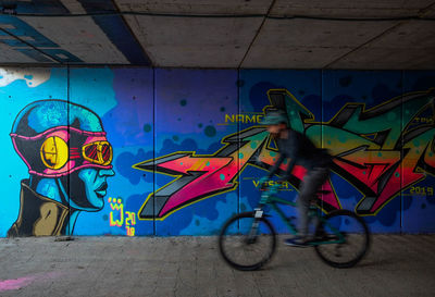 Side view of graffiti on bicycle against wall