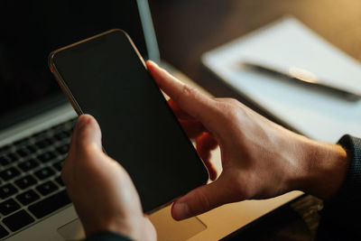 Midsection of man using mobile phone